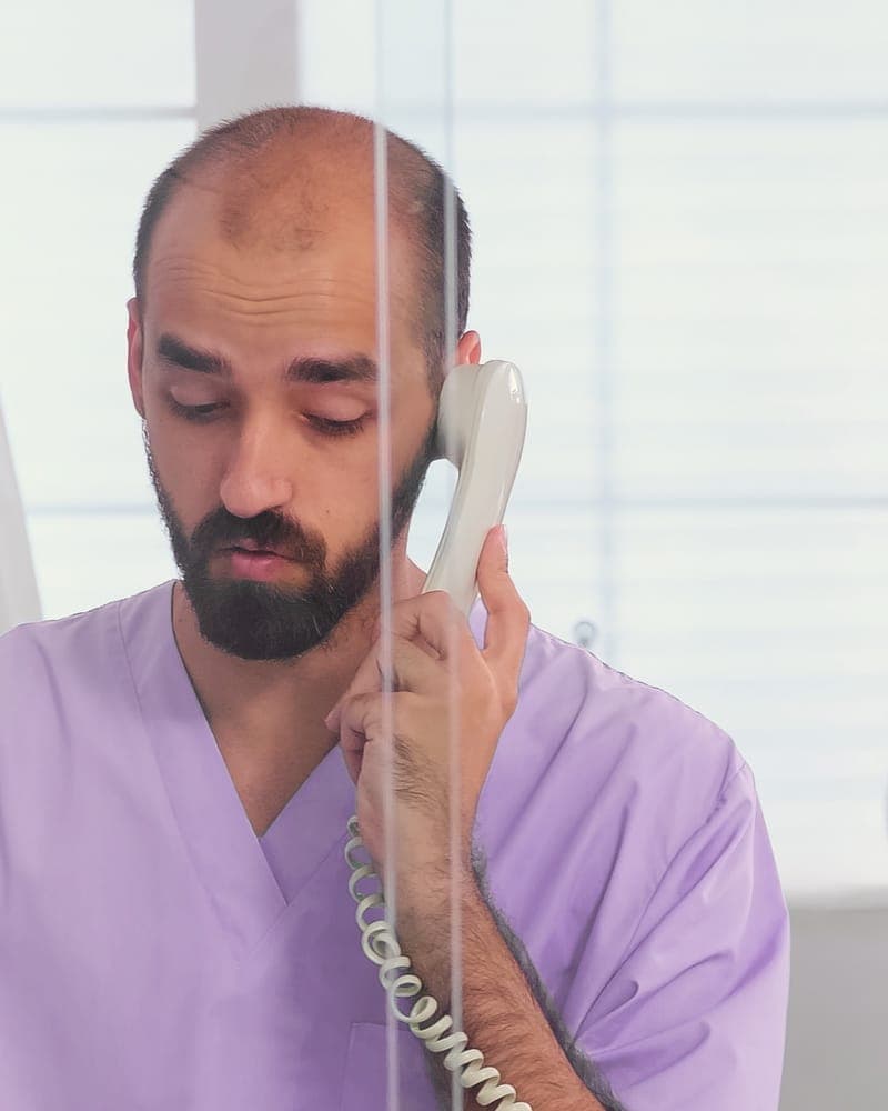 Hollis on the phone behind the front desk.