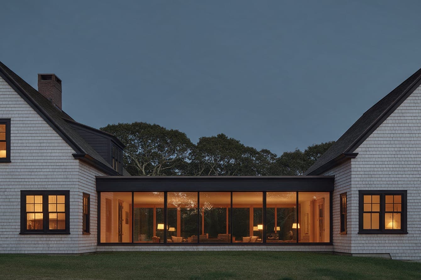 The glass hall between the two gables of Gable Pair, lit at dusk.