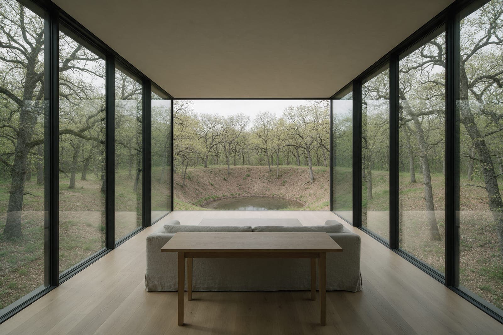 Inside the bridge room at Kettle House: glass on both long sides, oak woods all round and the hollow falling away beyond the windows.