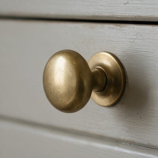 An unlacquered brass knob on a painted door.