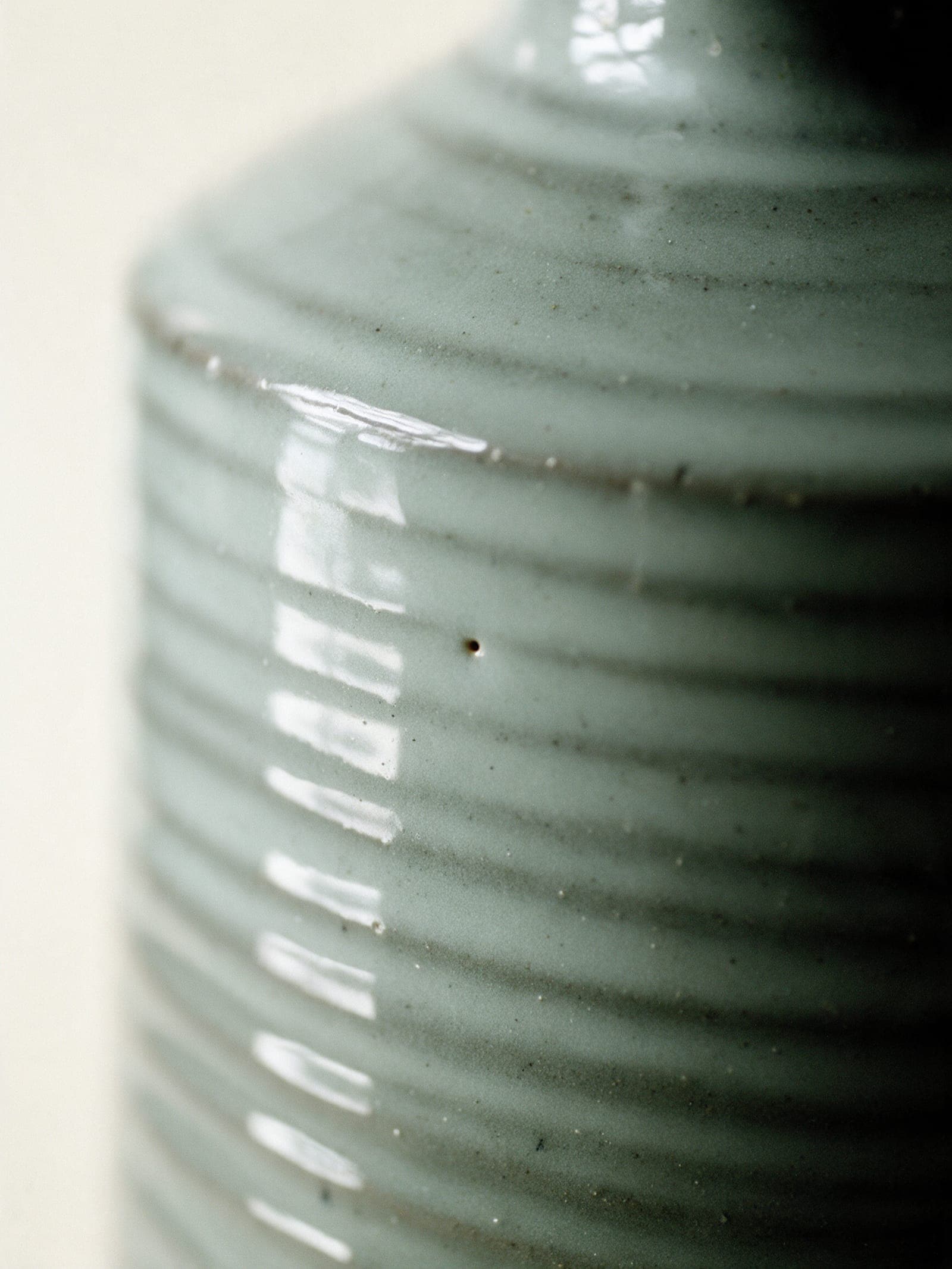 A 1 mm pinhole in the ash glaze at a vessel's shoulder