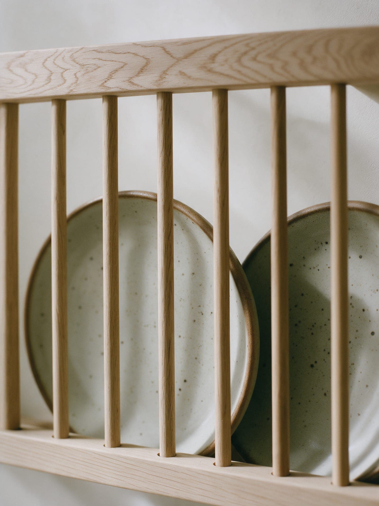 White oak dowels seated in the top rail, a plate standing between them