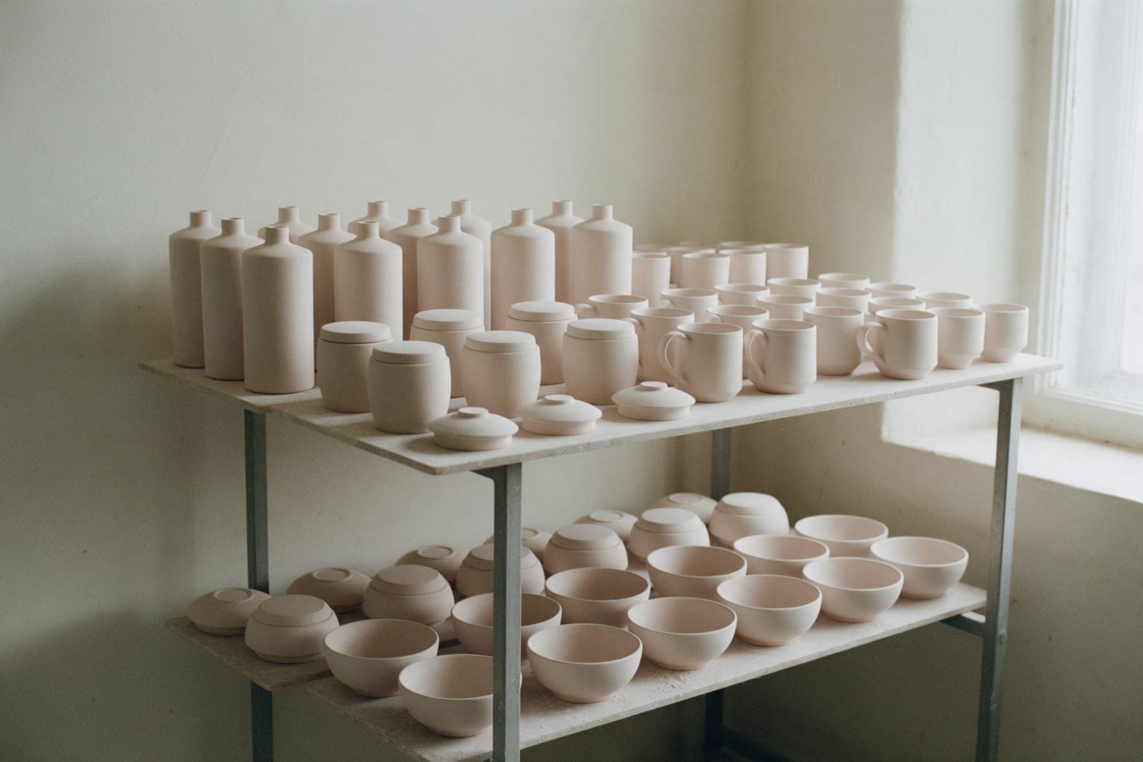 Bisque-fired bowls, cups, jars and bottles on ware boards