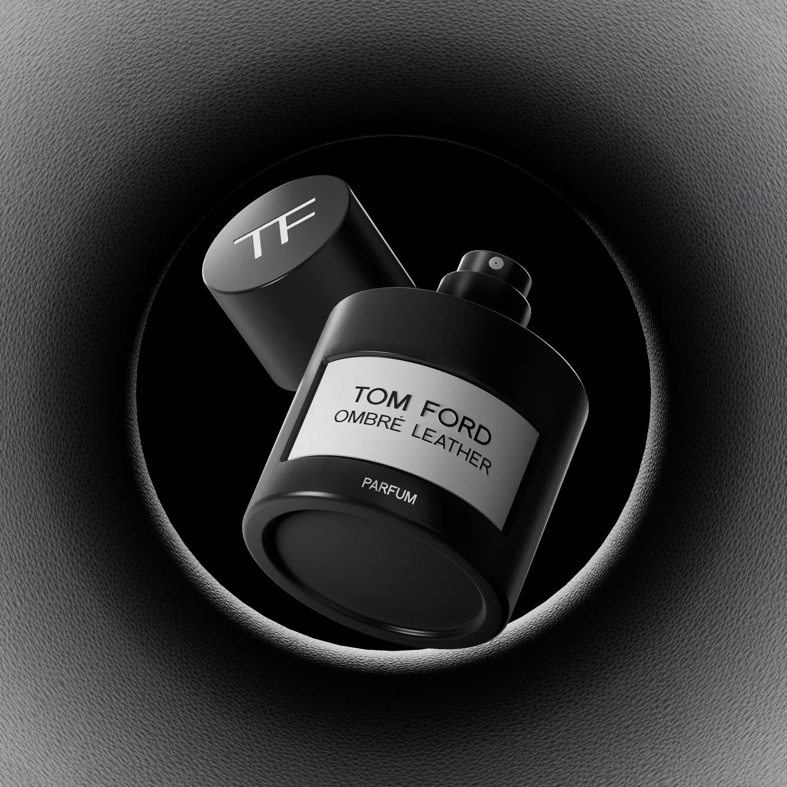 CG study of a Tom Ford Ombré Leather parfum bottle and its cap floating inside a dark circular recess.