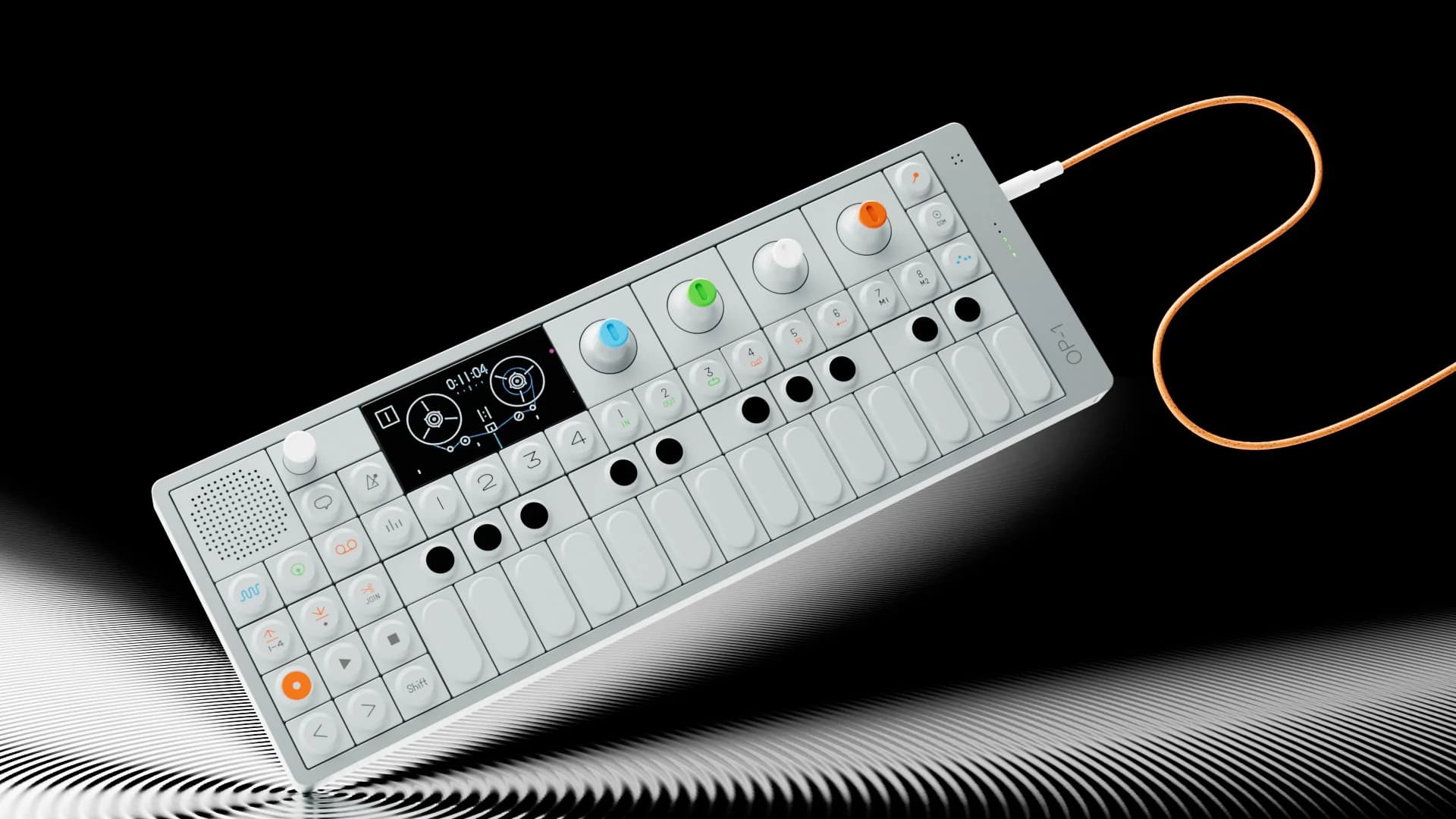 CG study of the OP-1 synthesizer on a black and white striped ground with an orange cable.