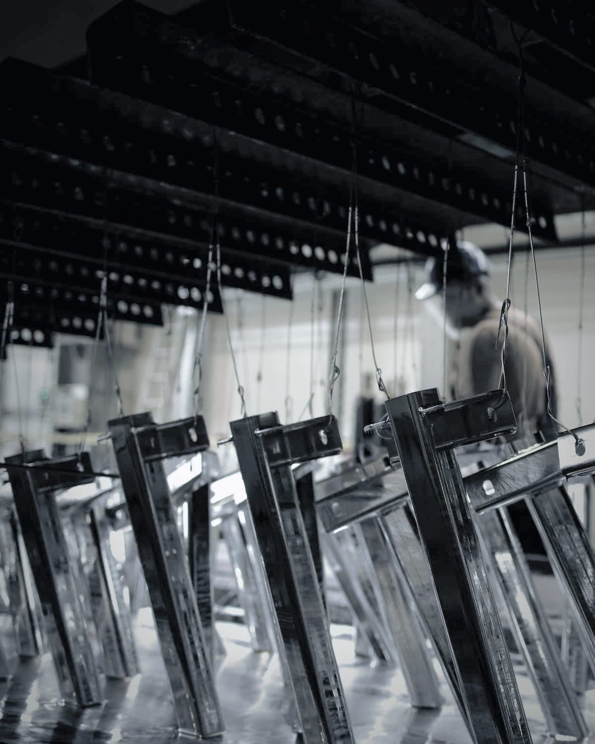 Welded steel frames hanging from wires on a zinc plating line