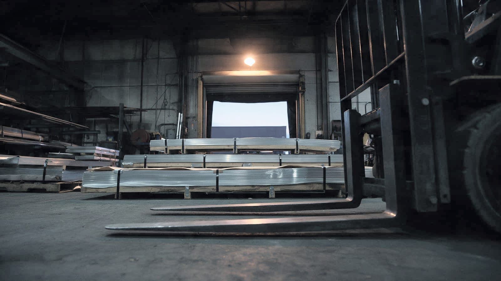 Receiving dock at dawn with sheet stock and a forklift