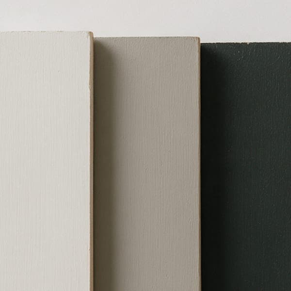 Three painted sample boards: off-white, warm grey and green-black.